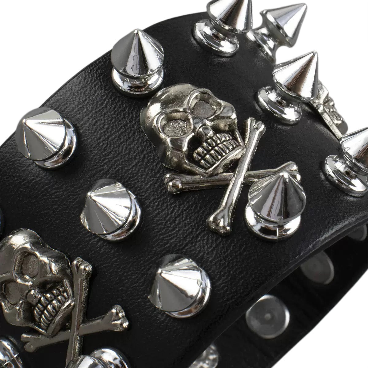 Acercamiento a los detalles de calaveras y picos metálicos del brazalete de piel sintética.