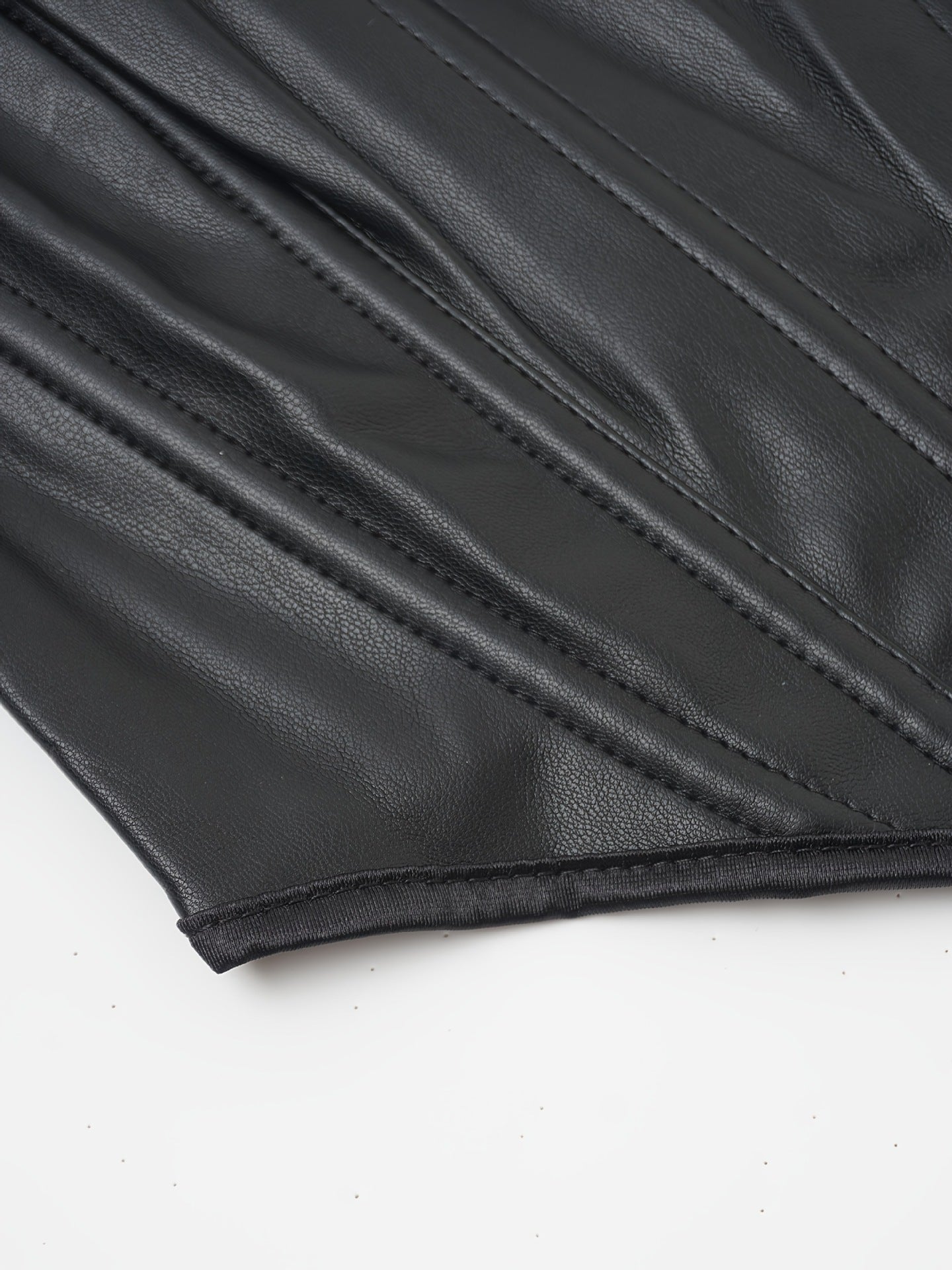 Primer plano de la textura premium de piel sintética y acabado de las costuras del corset.