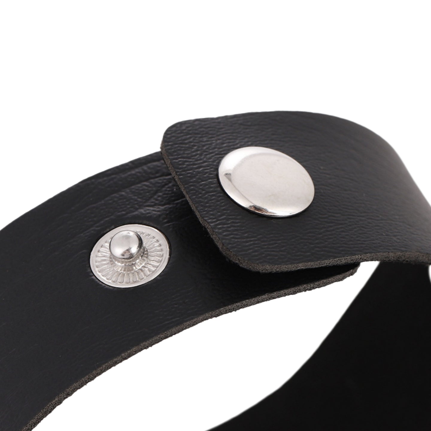 Primer plano de brazalete de piel sintética negra con anillo metálico central plateado y remaches.