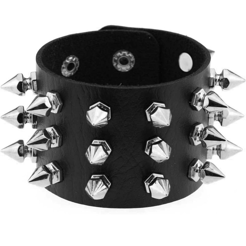 Detalle del brazalete de piel con tres filas de picos plateados y broches de presión.