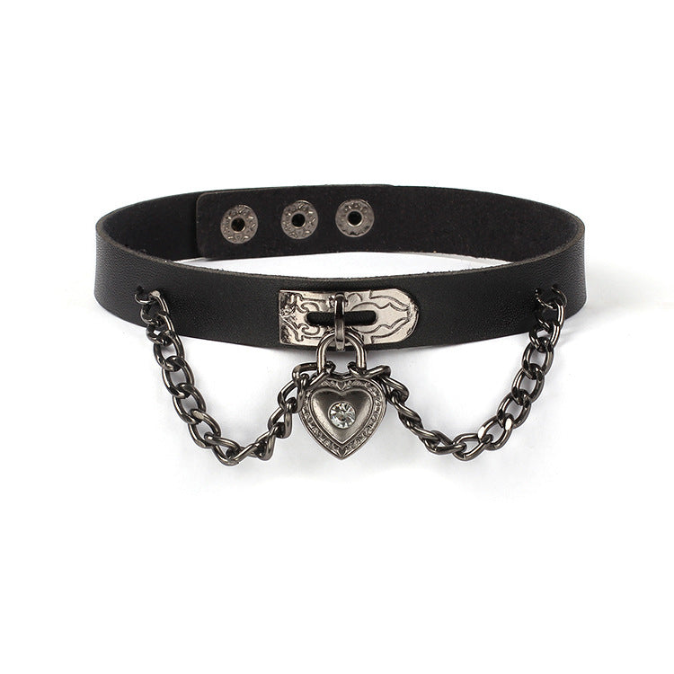 Vista frontal de gargantilla negra con adorno de corazón y cadenas para un look alternativo.