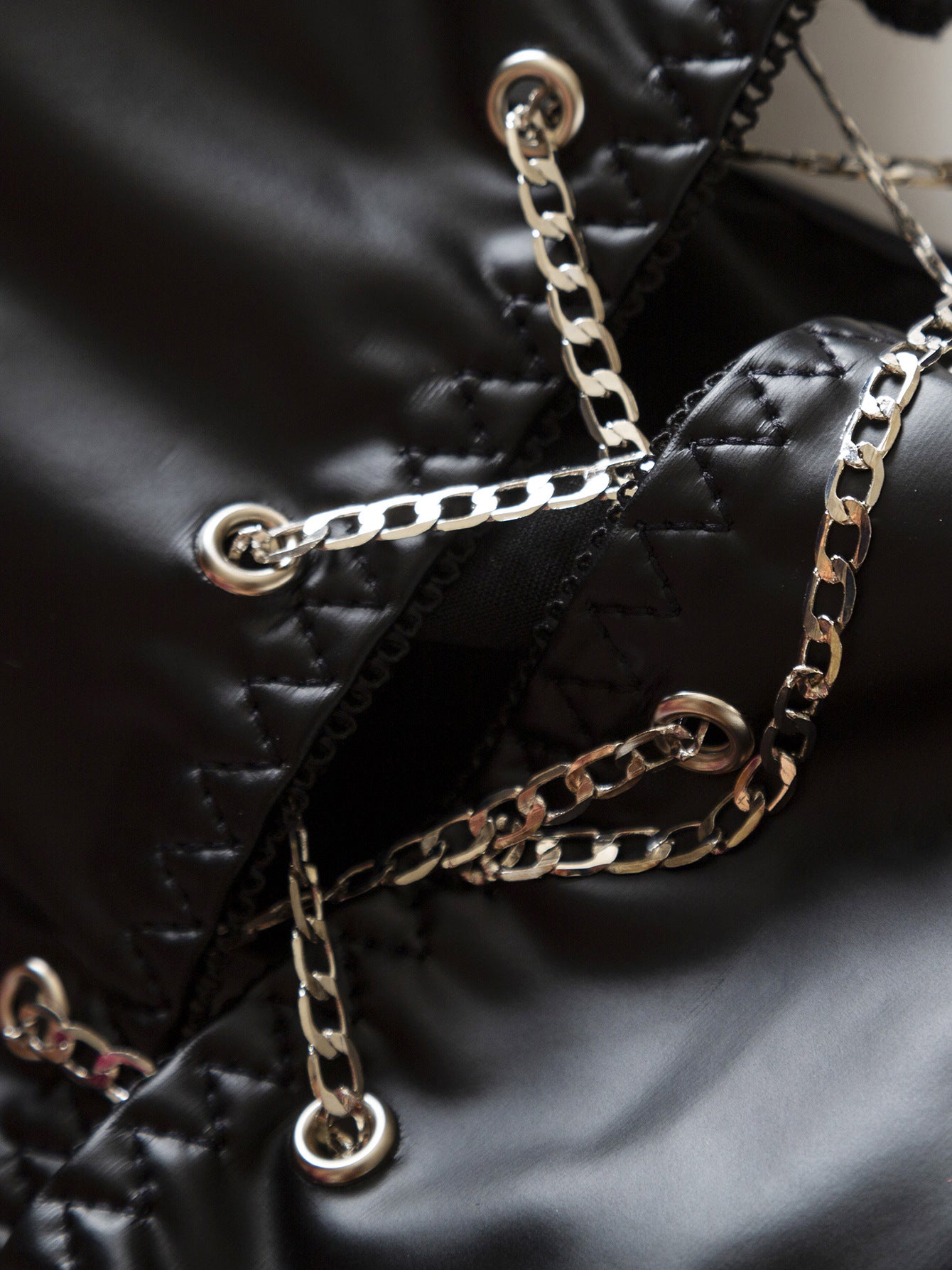 Acercamiento a las cadenas metálicas entrelazadas en el diseño frontal del corset.