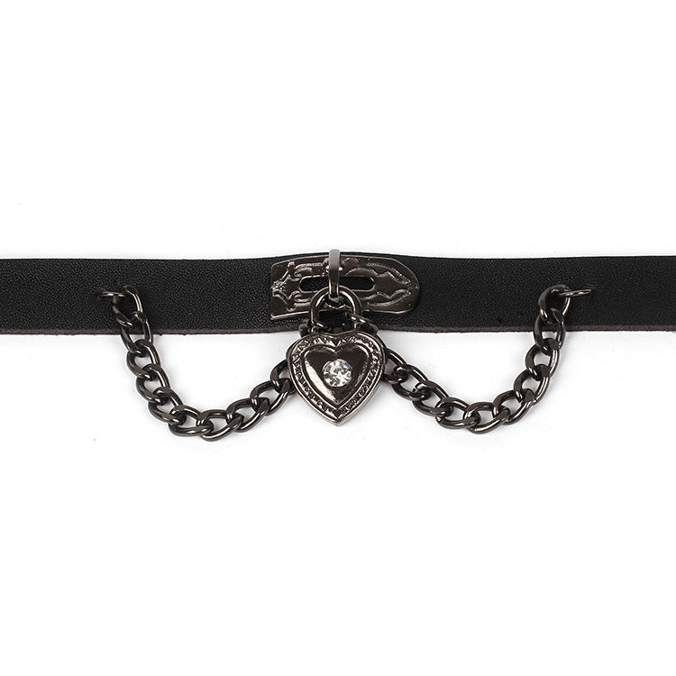 Primer plano del dije de corazón con cristal y cadenas laterales del choker gótico.