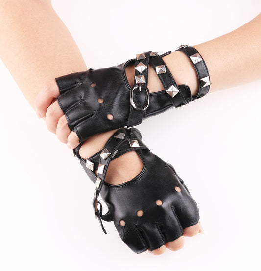 Par de guantes sin dedos de piel sintética negra con remaches piramidales y hebillas metálicas.