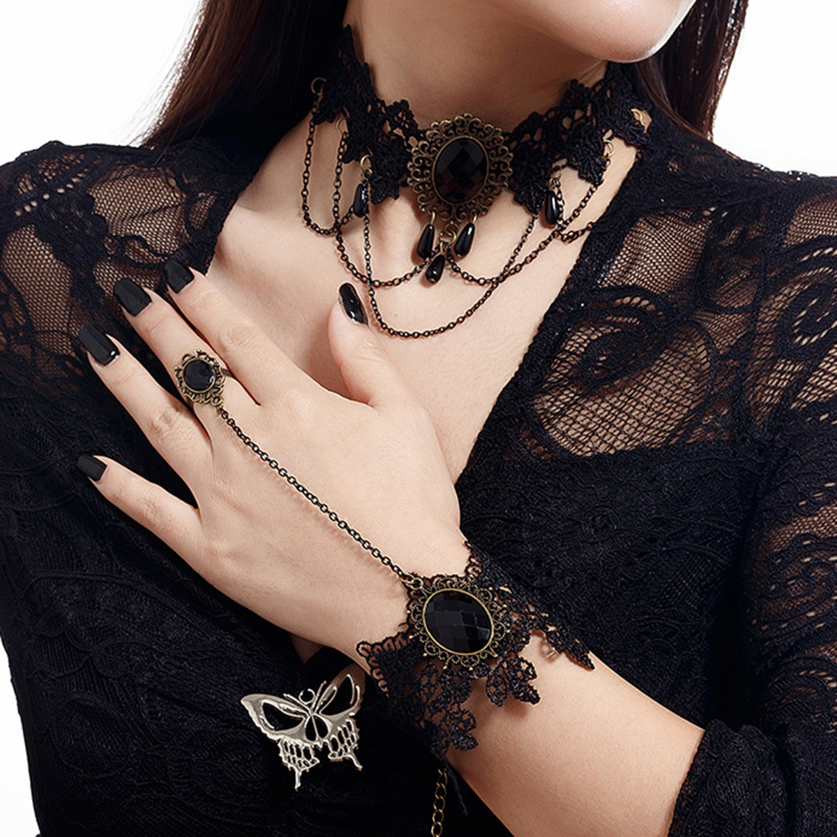 Modelo luciendo la pulsera de encaje negro con gema central y anillo ajustable.